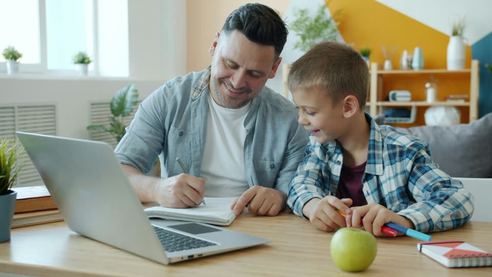 A parent and child working together at a laptop
